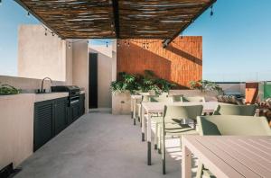 a restaurant with tables and chairs on a roof at Xaana Private Pool 2 bed wifi 300 Mbps Rooftop in Tulum