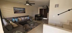 ein Wohnzimmer mit einer Couch und einem Deckenventilator in der Unterkunft Brisas Del Mar Villa 3 BR 2 BA with pool in Tijuana