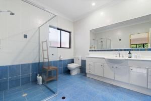 a bathroom with a sink and a toilet and a shower at 4BSpacious Cozy Family Entertained home at Parkinson in Browns Plains +26 photos
