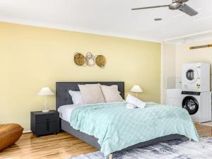 Een bed of bedden in een kamer bij Ocean View From Balcony 5BR Home with Pool at Redcliffe