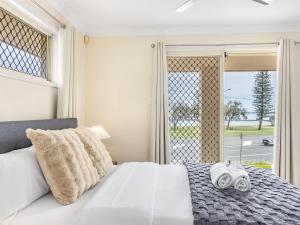 Een bed of bedden in een kamer bij Ocean View From Balcony 5BR Home with Pool at Redcliffe