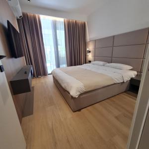 a bedroom with a large bed and a large window at Air Onia in Budva