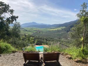 a table and two chairs on a hill with mountains at Casa del Sueño in Alora