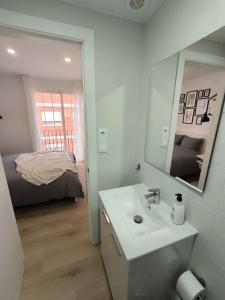 Un baño con lavabo, espejo y cama. en Cute little apartment, en Godella