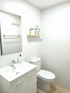 Un baño blanco con inodoro y lavabo. en Cute little apartment, en Godella 5 fotos más