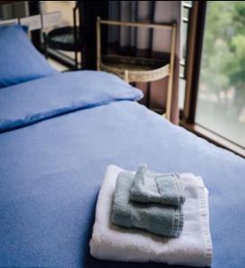 a pile of towels sitting on top of a bed at BV Taipei XinYi D in Taipei