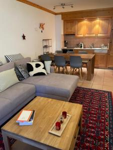 a living room with a couch and a table at Charme assuré in Crans-Montana