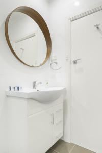 Un baño con un lavabo y un espejo en la pared. en Huge Designer Studio Next to Lovely Park, en Sídney