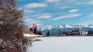 a snow covered lake with mountains in the background at Charme assuré in Crans-Montana