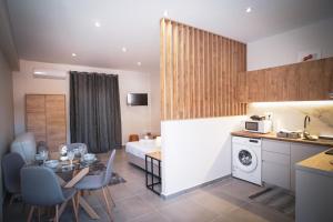 a kitchen and living room with a table and a bed at KA Luxury Apartments in Mantoúkion