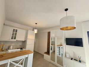 a kitchen with white cabinets and a counter top at Calypso Sea View Apartament Saranda in Sarandë +10 photos