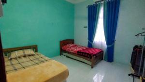 a bedroom with two beds and a window at AF Homestay in Bachok