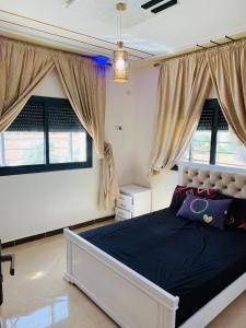 a bedroom with a large bed and two windows at Al confort in Fez +42 photos