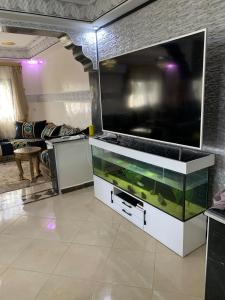 a living room with a large flat screen tv at Al confort in Fez