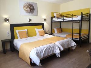 two beds in a room with two bunk beds at Hôtel Restaurant Aux Deux Roses in Neuf-Brisach
