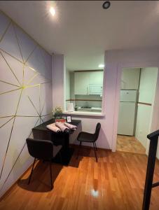 a room with a table and two chairs and a kitchen at Apartamentos de la Luz in Granada