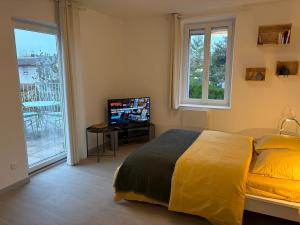 a bedroom with a large yellow bed and a balcony at Le Nid de Louise, near highway in Mulhouse