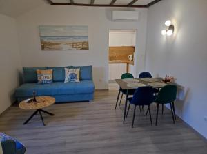 a living room with a blue couch and a table at Villa Mali Raj in Zaton