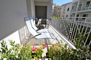 een balkon met een stoel en een aantal planten en bloemen bij Royal Sea House in Cefalù