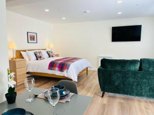 ein Schlafzimmer mit einem Bett, einem Tisch und einer Couch in der Unterkunft Viewforth Studio No.2 in Fort William