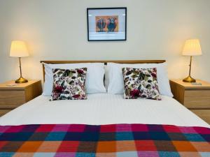 ein Schlafzimmer mit einem Bett mit Kissen und zwei Lampen in der Unterkunft Viewforth Studio No.2 in Fort William