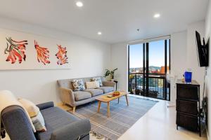 a living room with a couch and a table at Cityscape Delight with Skyline View - Free Parking in Auckland