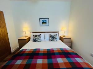 a bedroom with a large bed with two lamps at Viewforth Studio No.4 in Fort William