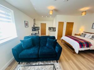 a living room with a blue couch and a bed at Viewforth Studio No.4 in Fort William