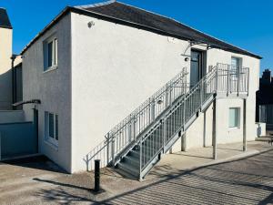 a white building with a staircase on the side of it at Viewforth Studio No.4 in Fort William