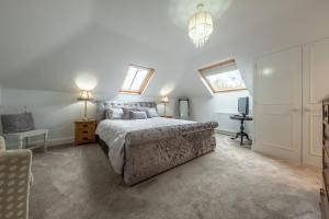 a bedroom with a bed and a television in it at Maltings Lodge in Chelsworth