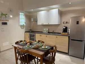 een keuken met een tafel met stoelen en een koelkast bij Casa nel vicolo in Trani