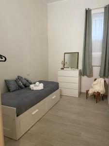 een slaapkamer met een bed met een ladekast en een spiegel bij Casa nel vicolo in Trani