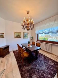 a dining room with a table and chairs and a chandelier at Villetta Rosa in Domodossola