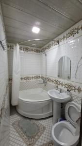 a bathroom with a toilet and a tub and a sink at Khiva Khan Hotel in Khiva