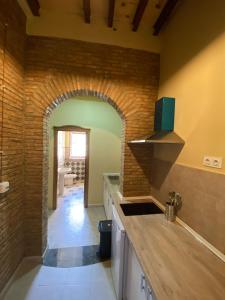 a kitchen with a brick wall and an archway at Apartamentos Abeto in Ronda
