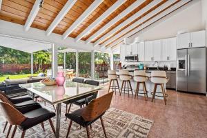 Una cocina y una sala de estar con mesa y sillas. en Pool and Spacious Backyard - Delray Beach Home, en Delray Beach