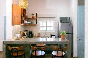 a kitchen with a counter with chairs and a refrigerator at Casa Baja - Depa completo 2 recámaras in Loreto