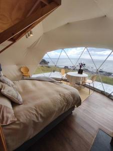 una camera da letto con un letto grande e un tavolo di Glamping in the middle of nature and ocean view a Punta Arenas