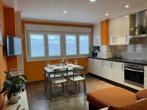 a kitchen with a table and chairs in a room at Os Boliños in Camariñas
