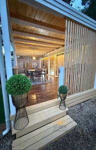 ビオグラード・ナ・モルにあるMobile Home LORENの鉢植えの植物が2本並ぶ木製デッキ