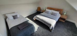 two beds in a small room with two lamps at Free Parking, Fast WIFI, Fully Equipped Kitchen, 15 min drive to Nissan, 20 min to Newcastle Sunderland, Ideal for Long Term Contractor etc Stays, Regular Housekeeping Option - Dwellcome Home Ltd 4 King Bedroom Townhouse - See Our Site for Assurance in South Shields