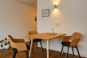 una mesa y sillas en una habitación con una pared en MEL&BENS Domshof Zentrum Balkon, en Bremen