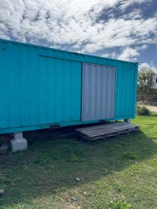 a blue container sitting on the grass in a field at Dpto conteiner in Necochea