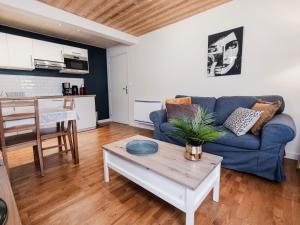 a living room with a blue couch and a table at Le Refuge in Lamoura