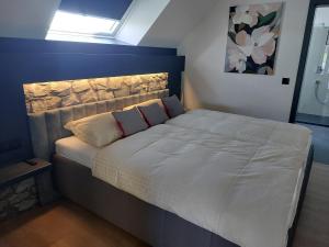 a bed with two pillows on it in a bedroom at L'Appart - New Appartement - Free Parking - Self Check-in - Terrasse in Eynatten