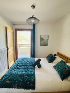 een slaapkamer met een bed met een blauw dekbed bij Le RandAulps in Saint-Jean-dʼAulps