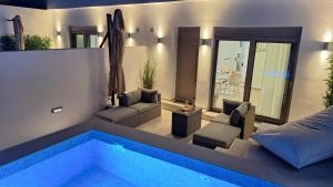 a villa with a swimming pool and a living room at BLU Faflagkos Bay Luxury Suites in Psari Forada