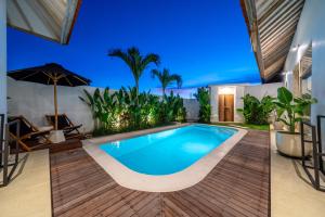 a swimming pool in a villa with an umbrella at La Palma - Sleek, Stylish & Spacious - Brand New 2-Bedroom Villa with Large Pool in Canggu! in Canggu +4 photos