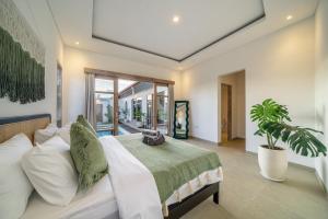 a bedroom with a bed and a potted plant at La Palma - Sleek, Stylish & Spacious - Brand New 2-Bedroom Villa with Large Pool in Canggu! in Canggu