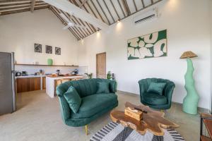 a living room with two green chairs and a table at La Palma - Sleek, Stylish & Spacious - Brand New 2-Bedroom Villa with Large Pool in Canggu! in Canggu